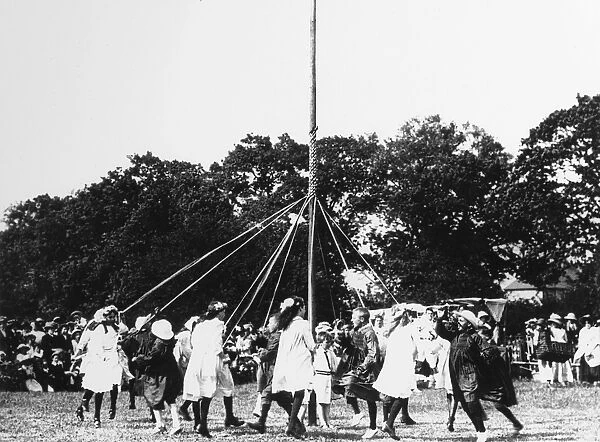 Children dancing round a maypole