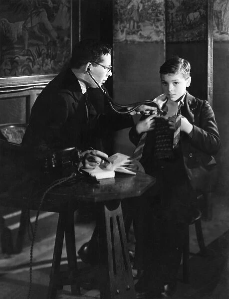 Doctor with stethoscope examines boy