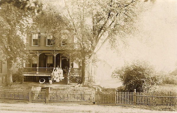 Women and children posing on front steps of house, USA