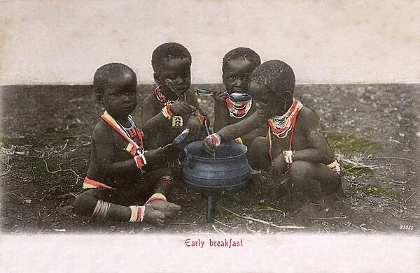 Four young Zulu children enjoy an early breakfast