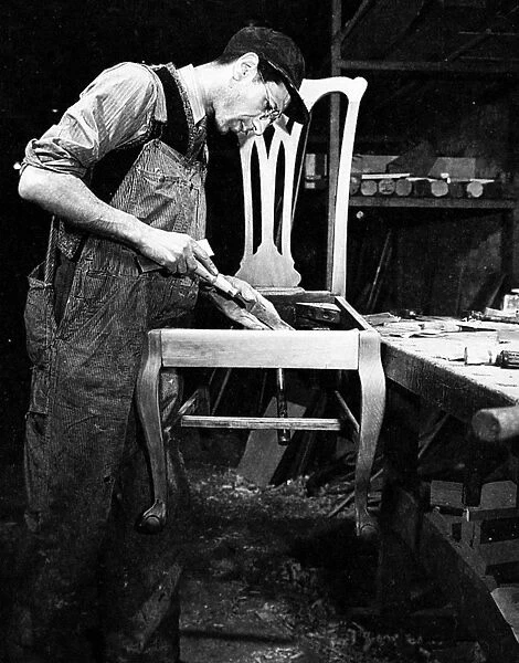 IMMIGRANT CABINETMAKER. An Italian immigrant cabinetmaker at work on a chair