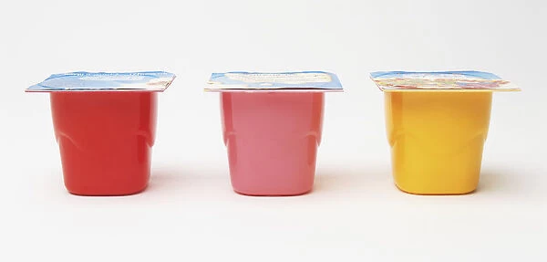 Three cups of yoghurt, red, pink and yellow