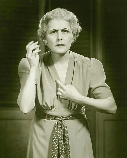 Distraught woman gesturing in studio, portrait