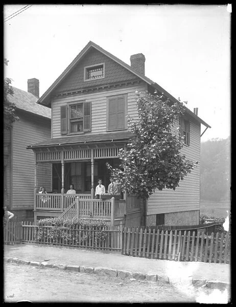 Four children pose on the porch of a house on a river or lake, Inwood, New York, c. 1910