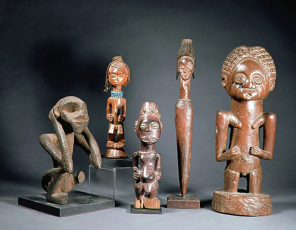 Collection of African tribal carved figures LtoR: crouching figure from the Bakwa Luntu tribe; two male figures from the Songye tribe of Zaire; charm figure from the Mitsogho tribe; male figure from the Luba tribe of Zaire (wood)