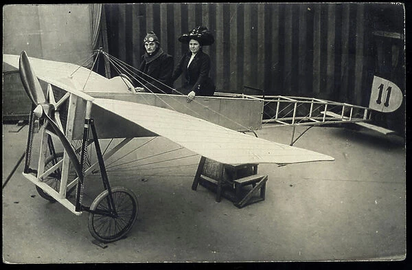 Couple poses in the replica of a Bleriot aircraft, 1910