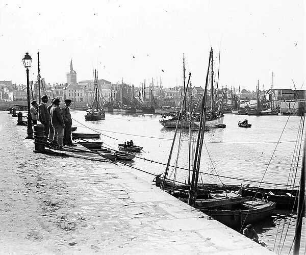 France, Pays de la Loire, Vendee (85), Les Sables-d'Olonnes: sailors on the port at the feet of reverberes contemplate the boats returning to the port, at the bottom of La Chaume and its church, 1925