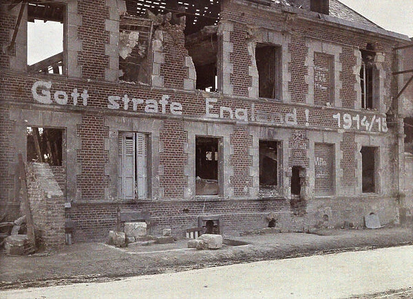 German army slogan on the wall of a damaged brick building: 'May God punish England