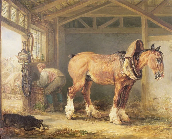 A groom with carthorse in a stable
