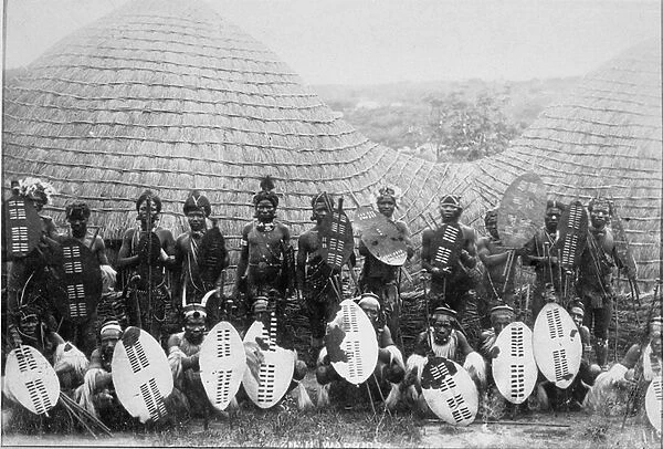 Group Portrait of Zulu Warriors outside a hut, c. 1875 (albumen print)
