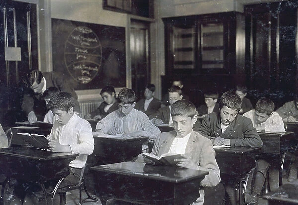 Image shows a class of immigrants in a night school, 1909