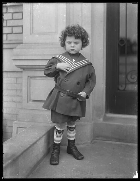 Little boy in sailor suit on front stoop of Vermilyea Avenue apartment building, c