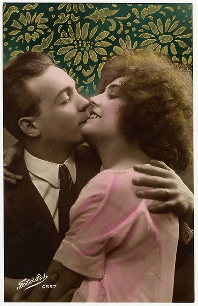 Two lovers kiss each other while smiling. Photograph of 1906-1910