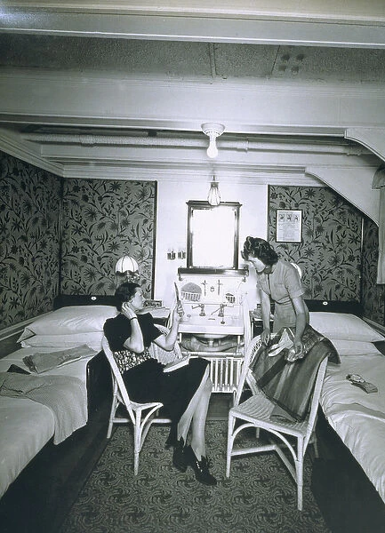 Maid helping her mistress undress aboard the RMS Scythia (b  /  w photo)