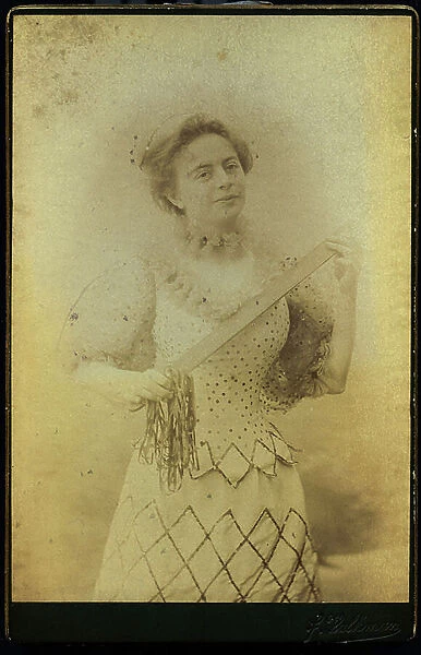 Professional photo of a seamstress with a cutting instrument, 1885