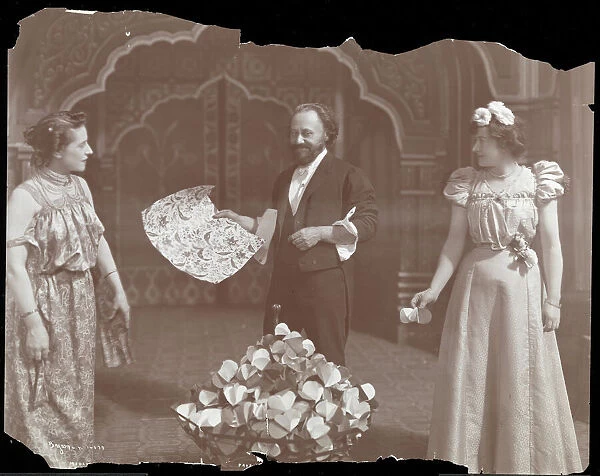 Professor De Kolta on stage with two women, 1902 (silver gelatin print)