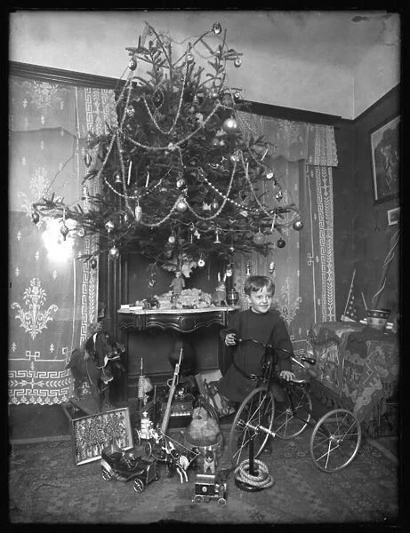 Seymour boy posed with tricycle beside Christmas tree in parlor