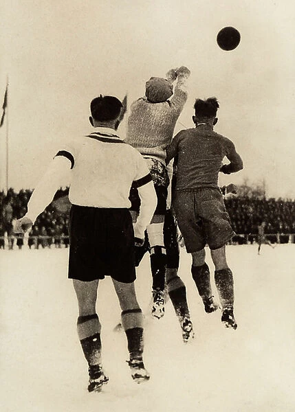 Soccer players in a moment of action on a snowy field, Italy, 1920 (b / w photo)