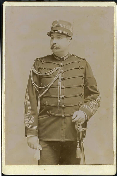 A soldier poses in a uniformed studio, 1890