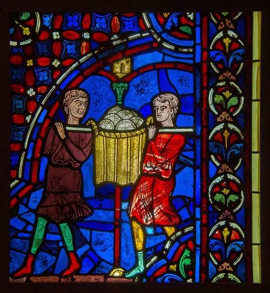 stained glass representing bakers in the Middle Ages carrying a basket filled with bread