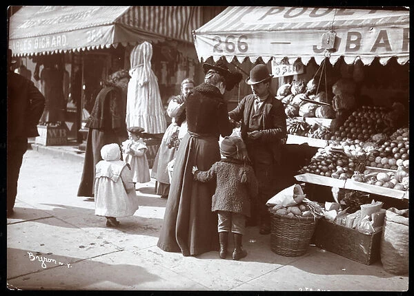 View of women with children shopping at a fruit and vegetable stand at 266 7th Avenue