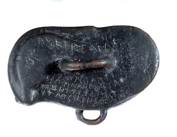 Votive weight in bronze in the shape of an osselet with a dedication in Greek to Apollo