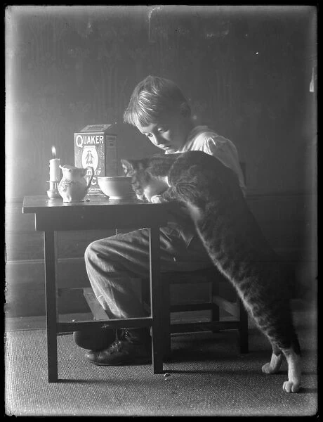 William Gray Hassler and Reddy the cat, eating Quaker puffed rice cereal, c
