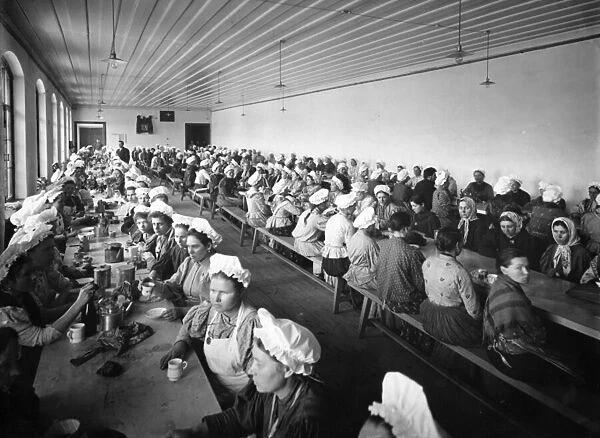 Women workers in a factory warehouse take a dinner break