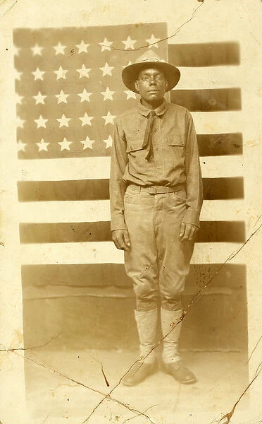 World War I soldier with American flag in background, 1914-18 (b  /  w photo)