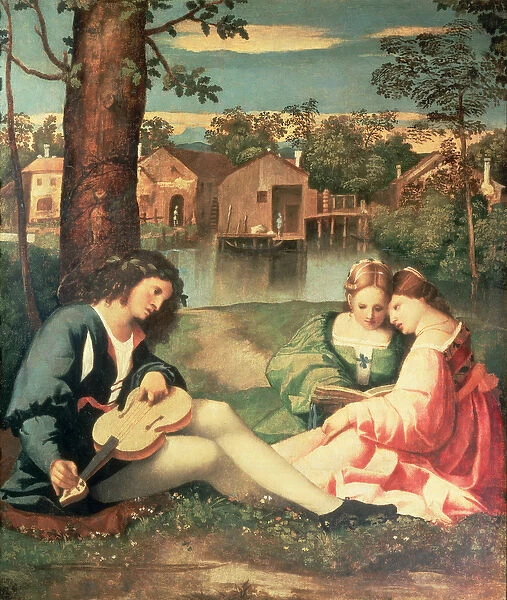 Youth with a guitar and two girls sitting on a river bank