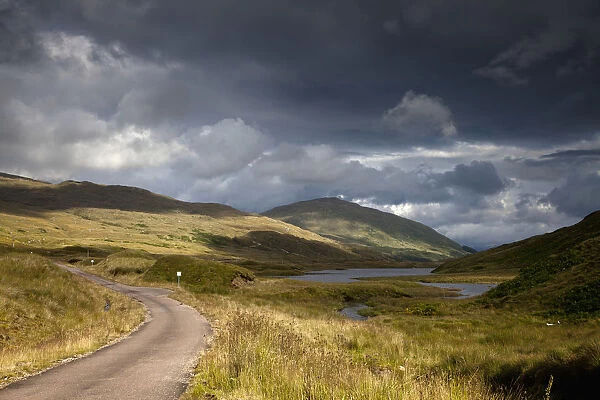 A Road Curving Through A Mountainous Landscape; Ardnamurchan, Argyl, Scotland