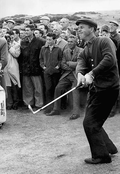 Arnold Palmer takes a swing as crowd look on golf