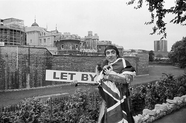 Keith Moon, drummer with British rock group The Who, draped in the Union Jack flag