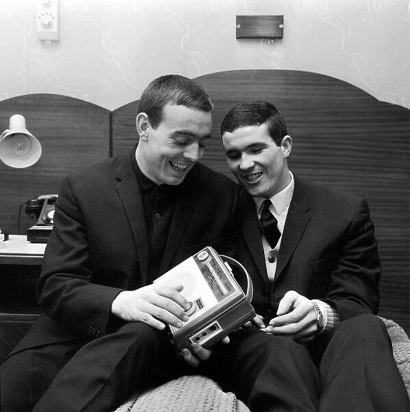 Liverpool player Ian St John shows off his portable radio to a team mate in his London