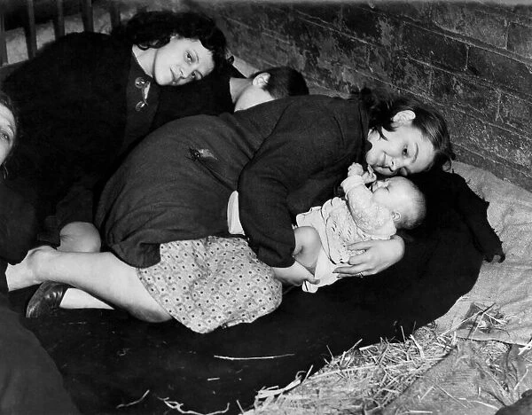 A Mother protects her baby whilst taking cover from air raid in a farmers barn
