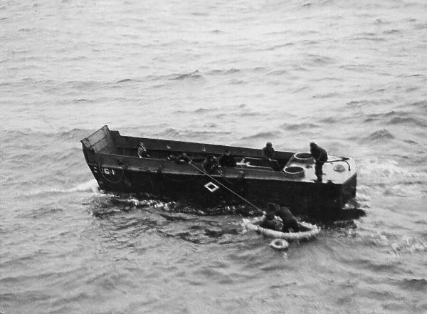 A Royal Navy landing craft picking up American survivors in Invasion Bay following a