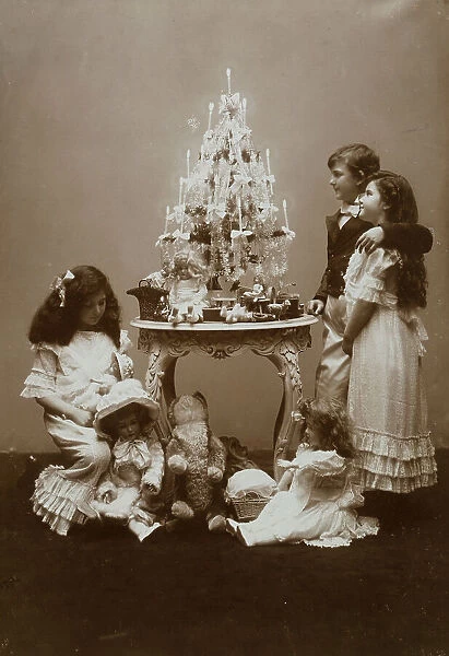 Children near a small table with a little Christmas tree and some toys