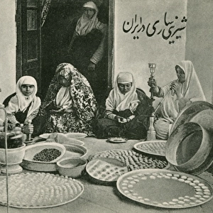 Arab women preparing trays of sweetmeats