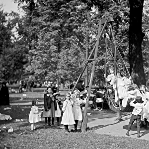 Children playing on the swings in a park playground in Ameri