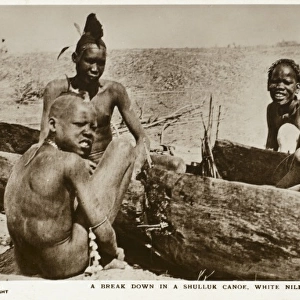 Dinka Tribesmen in carved-out canoe