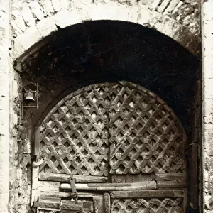 The fabulous gateway entrance to Chepstow Castle, Wales - lattice-work doors showing the repairs of age... Date: circa 1906