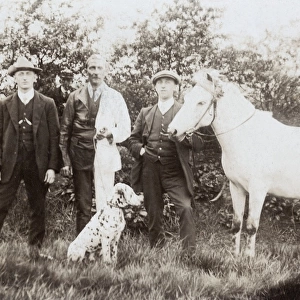 Three men with dalmatian and pony