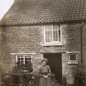 Woman and dog in front of cottage