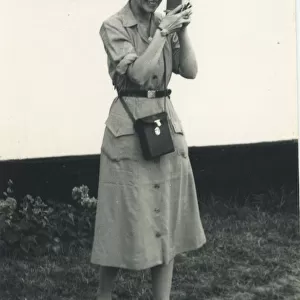 A woman using what looks to be a cine camera, probably a Bell and Howell 252