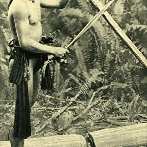 Young Kayan man making a blowpipe, Borneo, SE Asia
