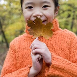 Girl holding an autumn leaf