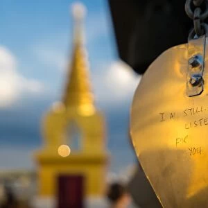 Golden prayer flag etching with Buddhist gold stupa in background, Bangkok, Thailand