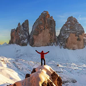Happy hiker enjoys the view of the Tre Cime di Lavaredo at sunset, winter view, Tre Cime di Lavaredo (Lavaredo peaks) (Drei Zinnen), Sesto (Sexten), Dolomites, South Tyrol, Italy, Europe