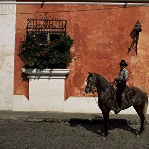 Man on horse in front of a typical painted wall