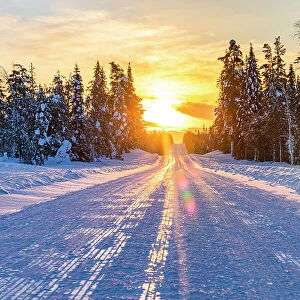 Sunset over an empty snowy road, Lapland, Finland